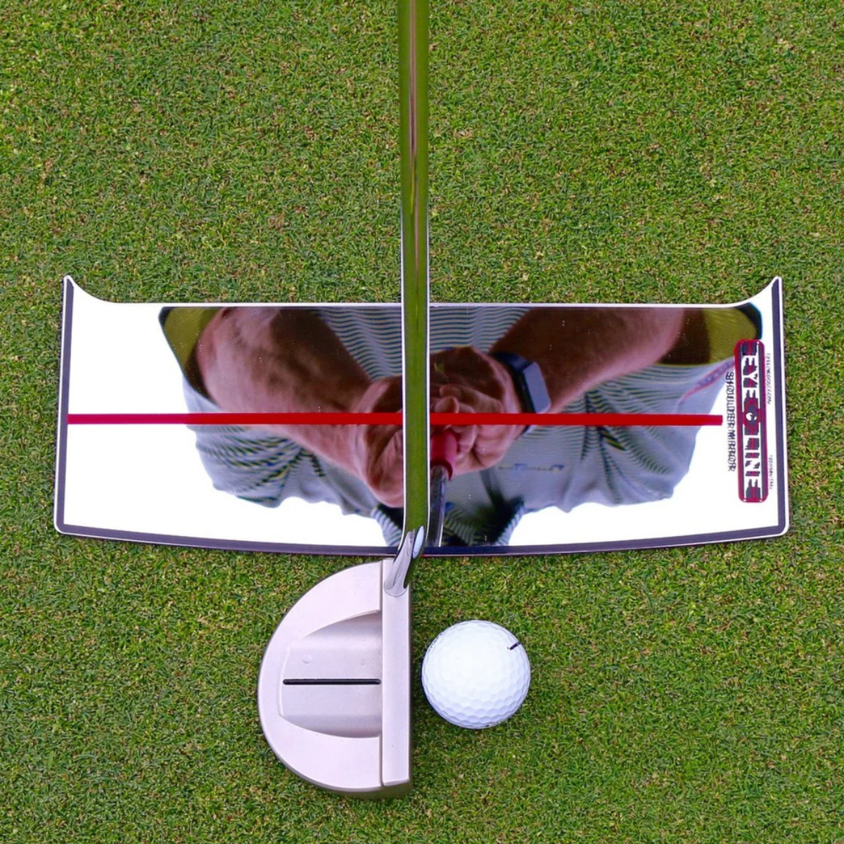 Golf shoulder putting mirror with a golf ball on a green surface, featuring a brand logo.