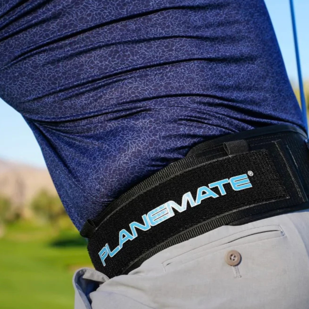 Person wearing a PlaneMate belt with a blurred outdoor background