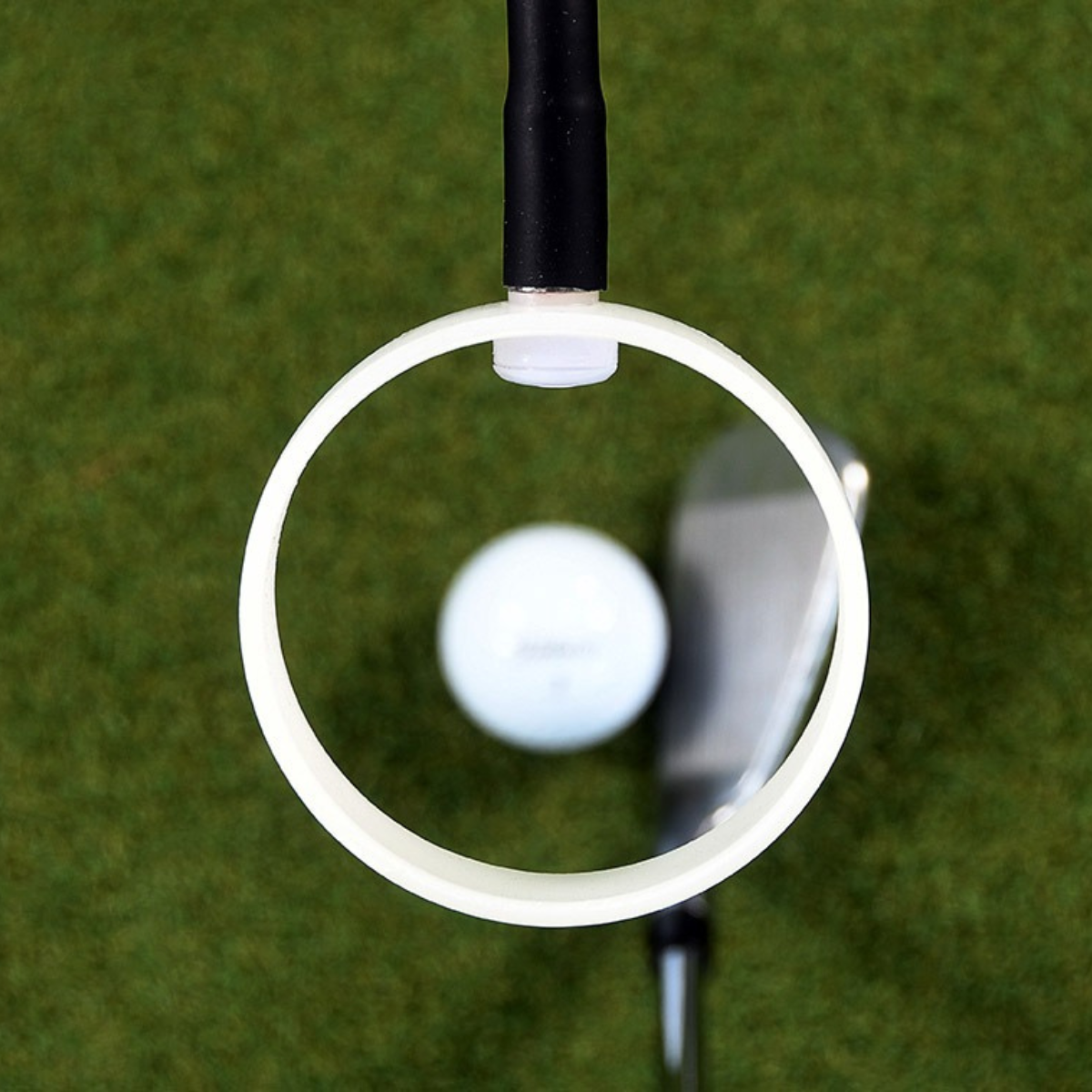 Golf ball on green grass with The Swing Eyes highlighting it