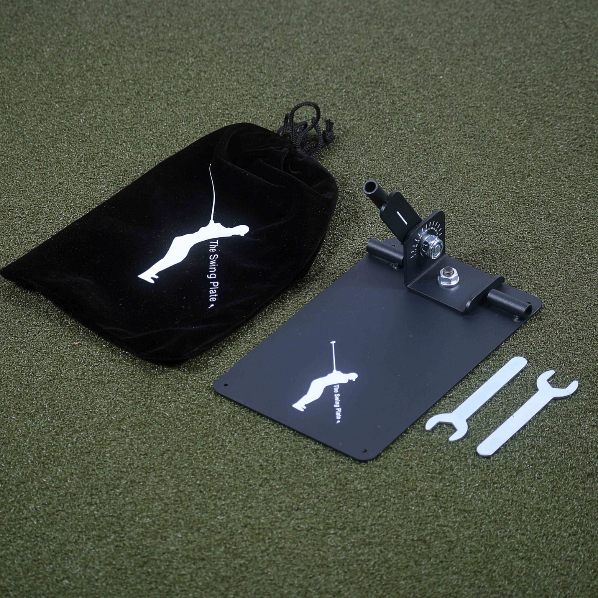 The Swing Plate with a black bag, and tools on a green surface