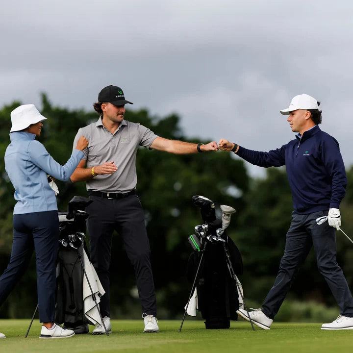 Three golfers on a golf course celebrating a great shot and an enjoyable round