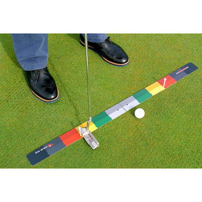 Golf putting practice device on a green surface with a person's feet in the background.