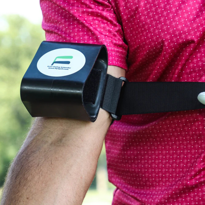 Person wearing the Flyt Golf Swing Extender with a visible brand logo, outdoors.