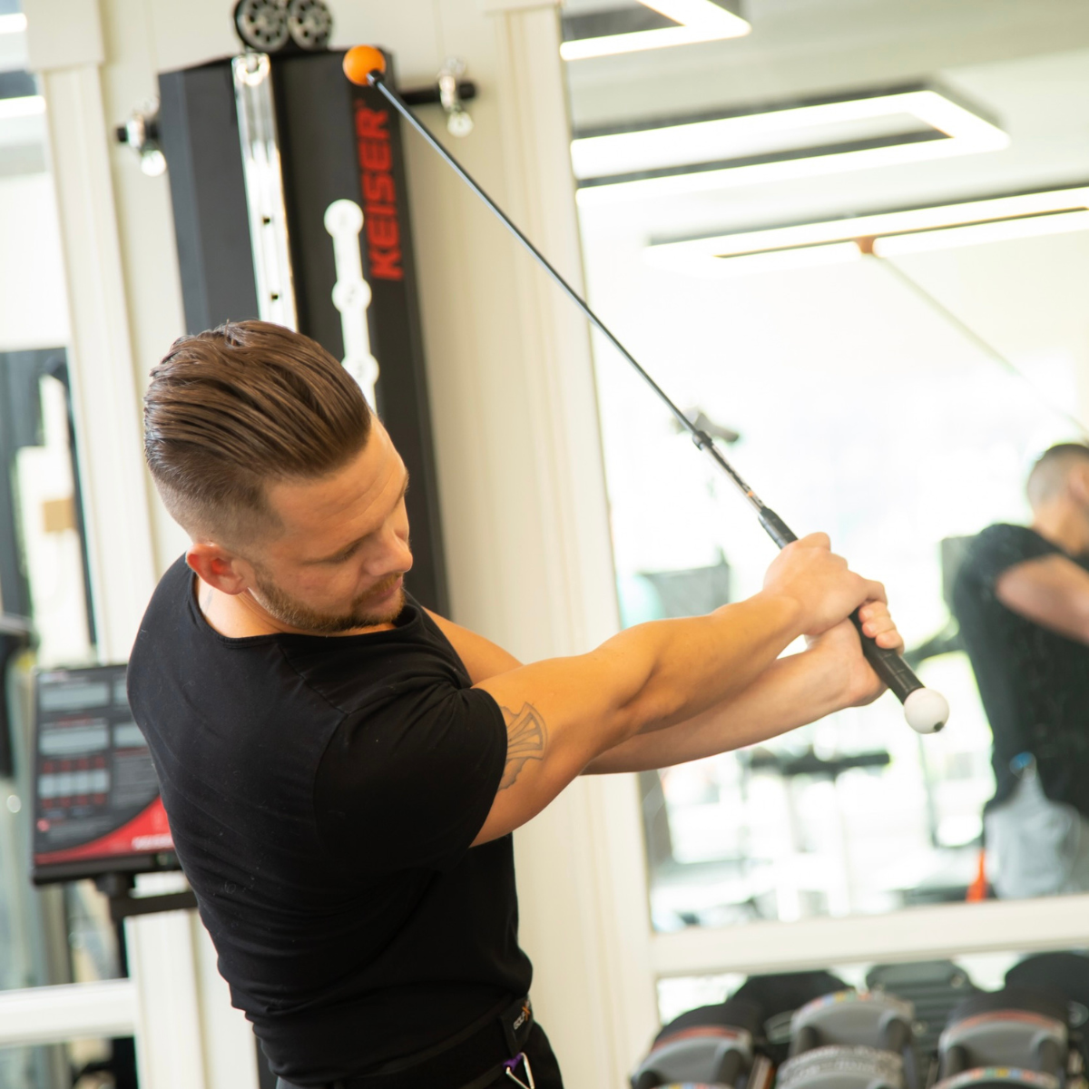 Man exercising with a weight machine in a gym setting
