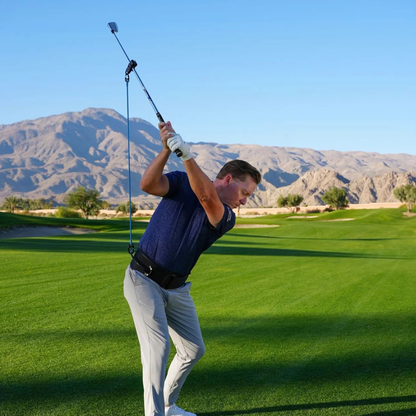 Man playing golf with the PlaneMate on a green course with mountains in the background