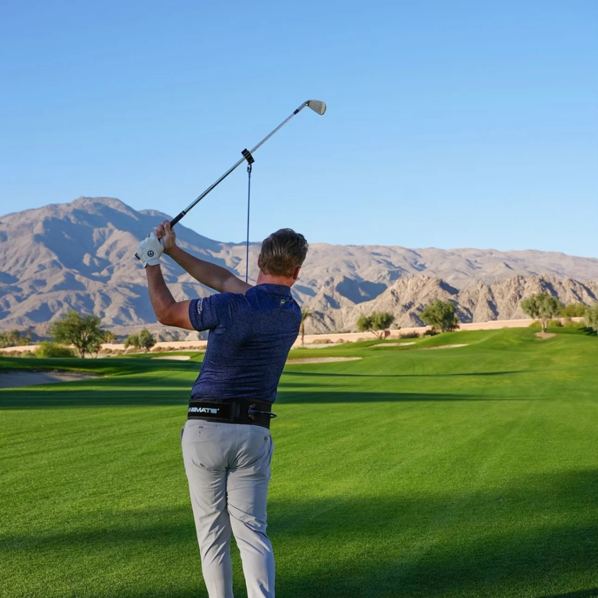 Golfer in action with the PlaneMate on a golf course with mountains in the background