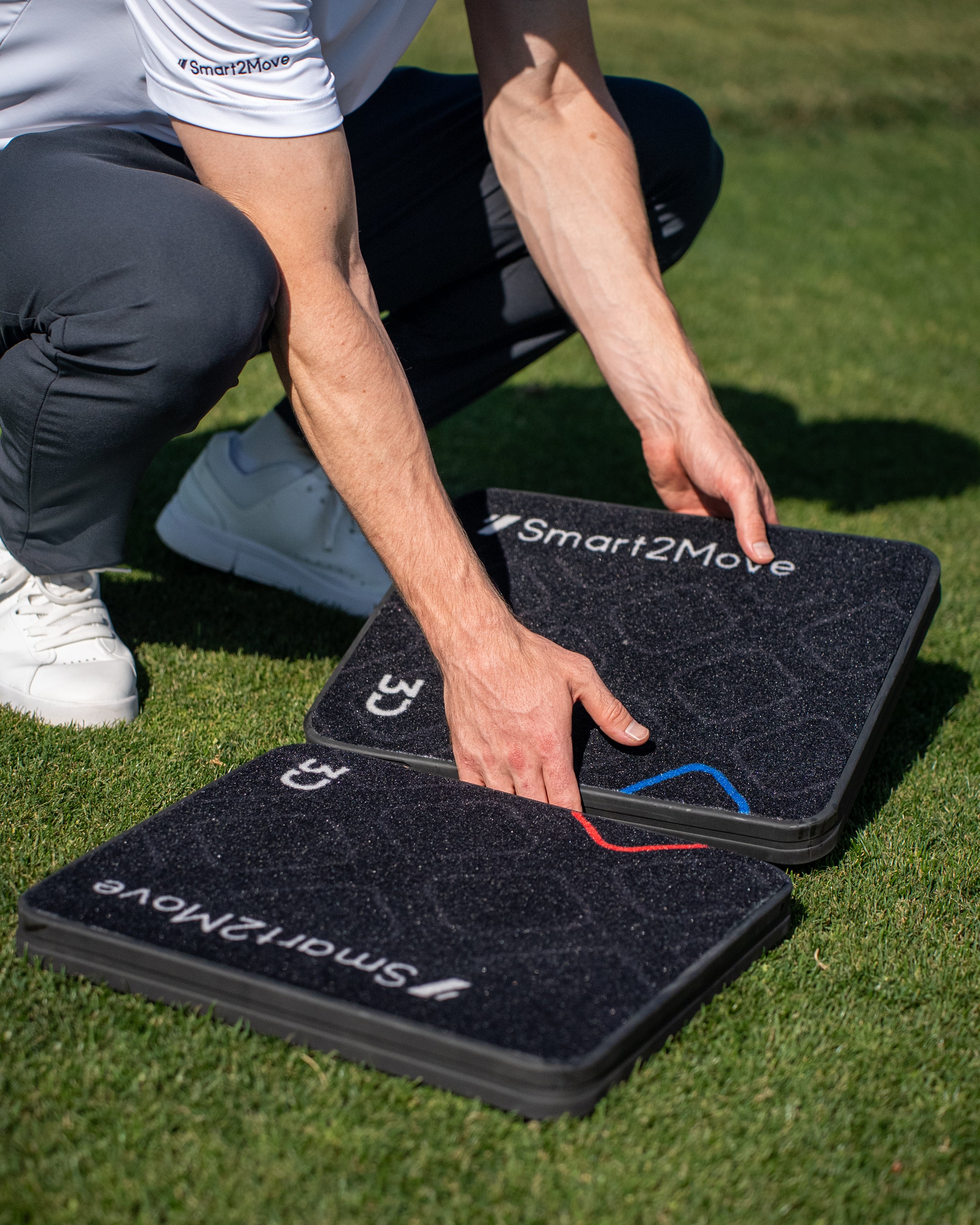 Person interacting with Smart2Move balance boards on grass
