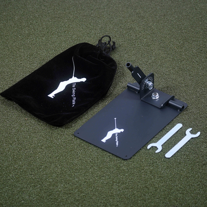 The Swing Plate with a black bag, and tools on a green surface