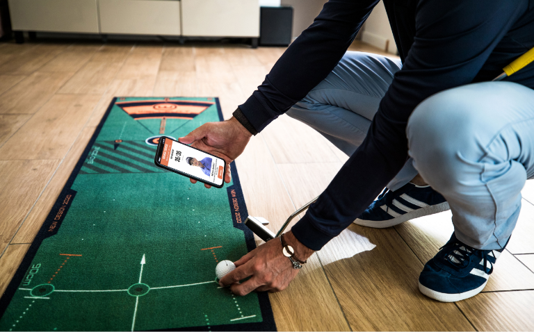 Person using a the Wellputt app on a golf practice mat
